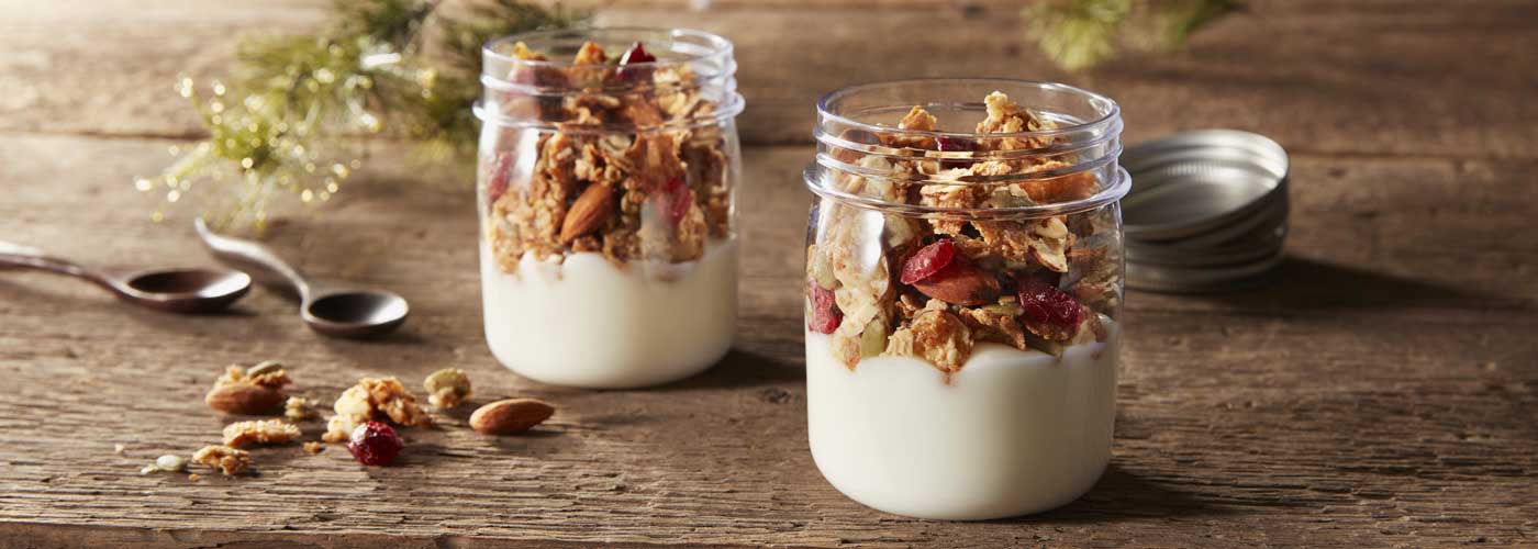 Two small, glass jars filled with yogurt and topped with Morning Summit cereal